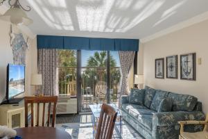 a living room with a couch and a table at Relaxing Oceanfront Condo - Holiday Pavilion 211 in Myrtle Beach