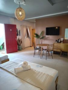 a bedroom with a bed and a table with chairs at Bellas Guest House in Pooc