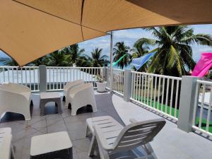 a patio with chairs and tables and an umbrella at Bellas Guest House in Pooc