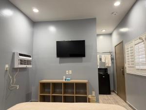 a bedroom with a tv on the wall at Casa Motel in Los Angeles