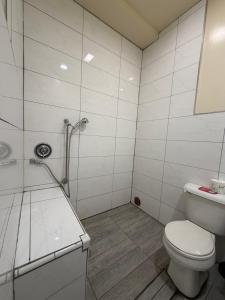 a white bathroom with a toilet and a shower at Casa Motel in Los Angeles