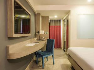 a bedroom with a desk and a bed and a chair at Ibis Styles Bangkok Sukhumvit 50 in Bangkok
