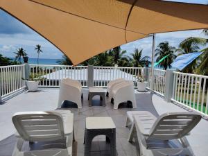 a patio with chairs and tables and an umbrella at Bellas Guest House in Pooc +7 photos