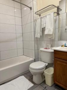 a bathroom with a toilet and a tub and a sink at Casa Motel in Los Angeles