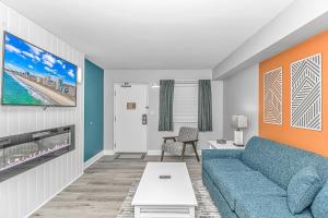 a living room with a blue couch at Pristine Oceanfront Oasis With Breathtaking Views- Camelot 1614 in Myrtle Beach