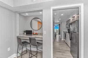 a kitchen with a table and chairs and a mirror at Pristine Oceanfront Oasis With Breathtaking Views- Camelot 1614 in Myrtle Beach +49 photos