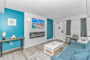 a living room with blue walls and a blue couch at Pristine Oceanfront Oasis With Breathtaking Views- Camelot 1614 in Myrtle Beach