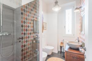 a bathroom with a sink and a toilet and a shower at Villa Casa Pini by Rent All Como in Bellagio +32 photos