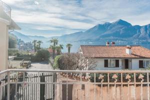 a house with a balcony with a view of the mountains at Villa Casa Pini by Rent All Como in Bellagio
