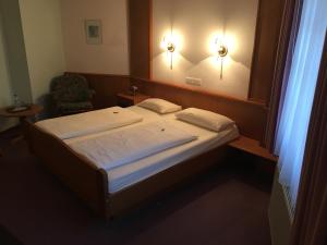 a bedroom with two beds and a mirror and a chair at Hotel Zur Buche in Bockhorn