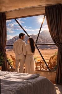 a man and a woman standing in front of a window at SELEN RUM LUXURY CAMP & Jeep Tours in Wadi Rum +175 photos