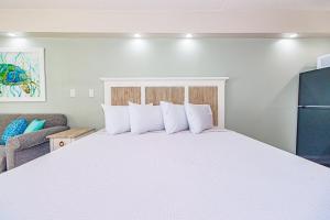 a bedroom with a large white bed and a couch at Ocean Front Condo Sea Mist 20509 in Myrtle Beach +35 photos