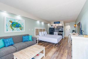 a living room with a couch and a bed at Ocean Front Condo Sea Mist 20509 in Myrtle Beach