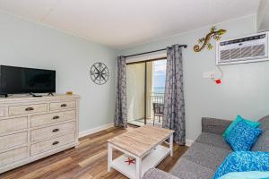 a living room with a couch and a tv at Ocean Front Condo Sea Mist 20509 in Myrtle Beach