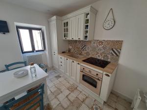 a kitchen with a sink and a stove top oven at Gredò Home & SPA in Gratteri
