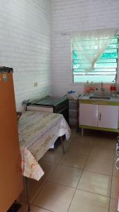 a small kitchen with a bed and a sink at Chácara chalé in Juquitiba +1 photo