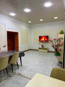 a living room with a fireplace and a tv on the wall at Şuvelan Villa in Baku