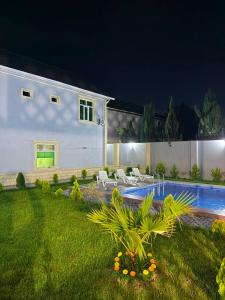 a white house with a swimming pool at night at Şuvelan Villa in Baku
