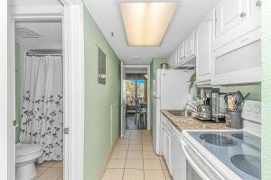a kitchen with a sink and a refrigerator at Updated 2nd Floor 1BR for 4! Sailfish 210 in Myrtle Beach