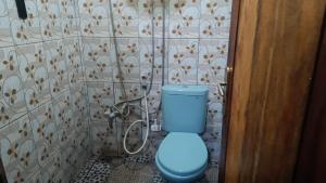 a bathroom with a blue toilet in a room at Watuburu Cottage & Restaurant in Ende