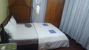a bed with two blue towels on it in a room at Watuburu Cottage & Restaurant in Ende