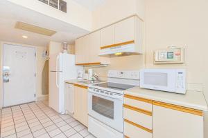 a kitchen with white appliances and white cabinets at Oceanfront Suite -Steps to SkyWheel! Yachtsman 402 in Myrtle Beach