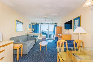 a living room with a couch and a table at Oceanfront Suite -Steps to SkyWheel! Yachtsman 402 in Myrtle Beach