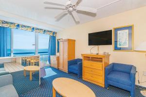 a living room with a couch and a tv at Oceanfront Suite -Steps to SkyWheel! Yachtsman 402 in Myrtle Beach +60 photos