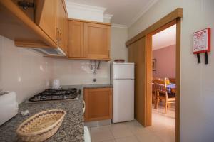 a kitchen with a stove and a white refrigerator at Complexo Eden Vilage by Garvetur in Vilamoura