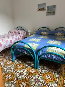 a bedroom with two beds and a tile floor at Sa Mùrtya casa vacanza in Viddalba