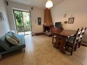 a living room with a table and a couch at Sa Mùrtya casa vacanza in Viddalba