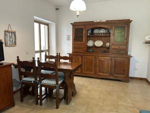 a dining room with a table and a wooden cabinet at Sa Mùrtya casa vacanza in Viddalba