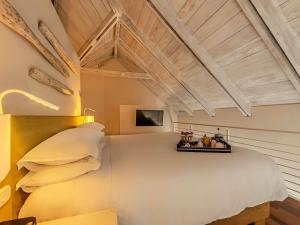 a bedroom with a large white bed with pillows at Hotel Boutique Bovedas de Santa Clara By Accor in Cartagena de Indias