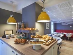 a bakery with bread and pastries on a counter at Hotel Mercure Brest Centre Les Voyageurs in Brest