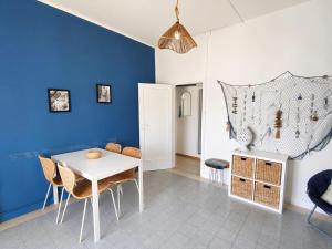 a dining room with blue walls and a table and chairs at CasaAzul in Sperlonga +8 photos