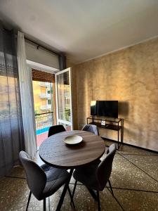 ein Wohnzimmer mit Tisch, Stühlen und Fernseher in der Unterkunft 3WHome in Rapallo