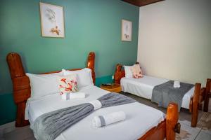 two beds in a room with blue walls at Pousada Aconchego in Pirenópolis +73 photos