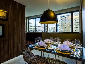 a dining room with a table with plates and glasses at Grand Mercure Belem do Para in Belém