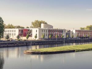 ein großes weißes Gebäude neben einem Gewässer in der Unterkunft Mercure Hotel Schweinfurt Maininsel in Schweinfurt