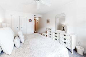 a white bedroom with a large bed and a mirror at Camelot 203B in Ocean City