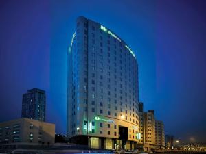 a tall building with lights on it at night at ibis Styles Makkah in Mecca