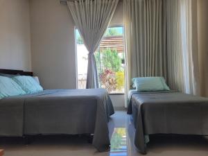a bedroom with two beds and a window at Santorini House Pousada e Restaurante in Araguaína +60 photos