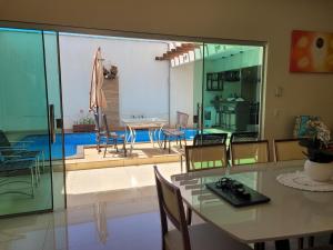 a dining room with a table and chairs and a patio at Santorini House Pousada e Restaurante in Araguaína