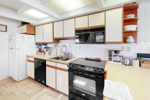 a kitchen with white cabinets and a black stove at White Sands Village 30 in Ocean City