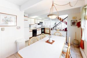 a kitchen and dining room with a white table and chairs at White Sands Village 30 in Ocean City +14 photos