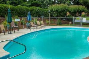 a large blue swimming pool with chairs and umbrellas at Deere Run 3B in White River Junction