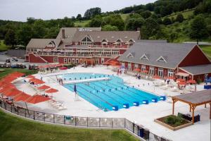 a large swimming pool in front of a large building at Quechee Hollow Comfort in White River Junction
