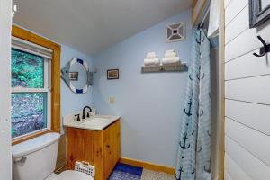 a bathroom with a sink and a toilet and a window at Beebe Pond Paradise in Castleton +49 photos