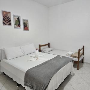 a bedroom with two beds and a chair at Casa tia Rosa, hospedagem familiar Guapimirim RJ in Guapimirim