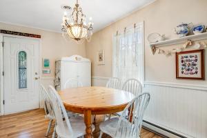 a dining room with a wooden table and white chairs at The Seashell Cottage in Ocean City